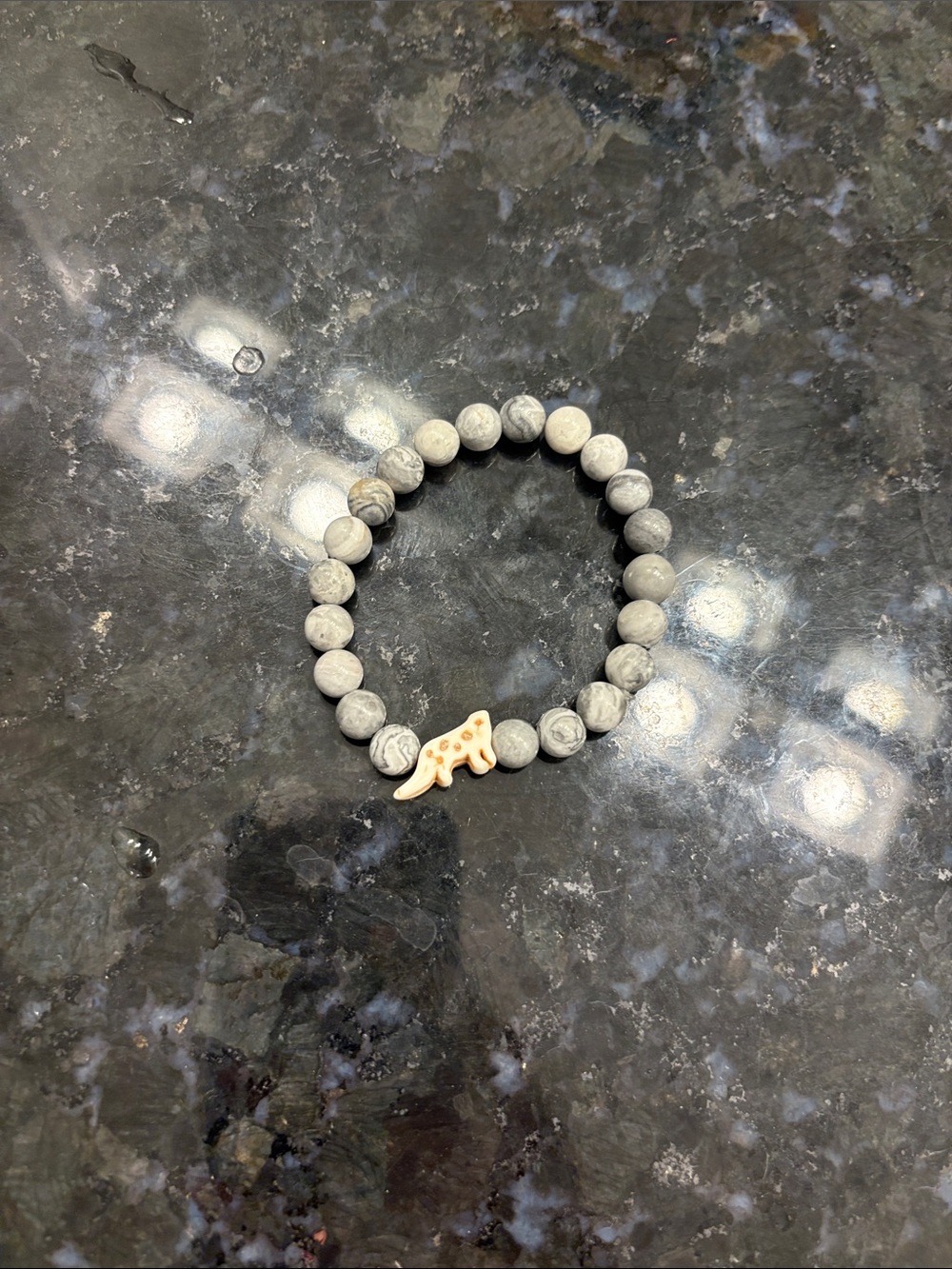 Gray Beaded Bracelet with Gold Dinosaur Charm